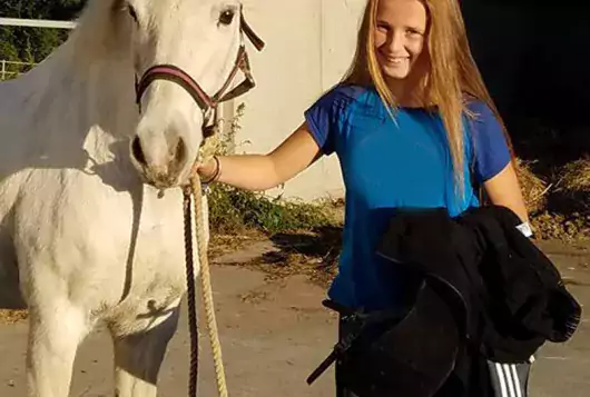 girl holding white horse