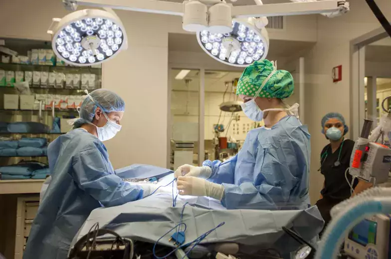 Two people in scrubs performing surgery
