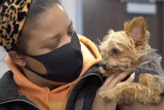 woman holds small dog after services at bronx cvc