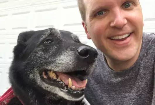 chris roy with his black and white dog, bear