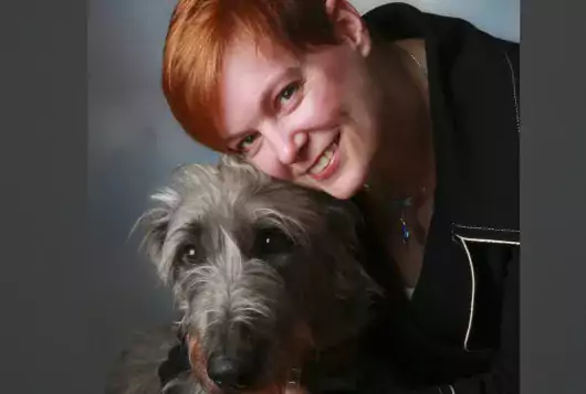 photo of Tina Wismer with shaggy gray dog